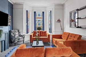 a living room with orange furniture and large windows at Fabulous House in Plymouth in Plymouth