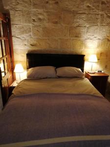 - une chambre avec un grand lit et deux lampes dans l'établissement Old refurbished Apartment in Bormla, à Cospicua
