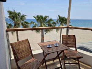 a table and two chairs on a balcony with the beach at Apartamentos Wundermar in Torredembarra