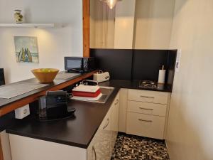 a small kitchen with a black counter top and a counter top at Apartamentos Wundermar in Torredembarra