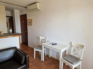 a small white table and two chairs in a room at Apartamentos Wundermar in Torredembarra
