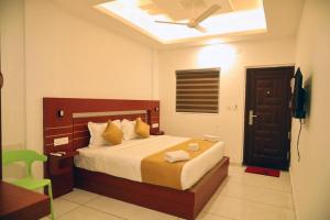 Schlafzimmer mit einem Bett und einem Deckenventilator in der Unterkunft Misty Avenue Premium Rooms in Anachal
