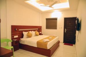 a bedroom with a bed and a ceiling fan at Misty Avenue Premium Rooms in Anachal +26 photos