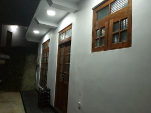 a hallway with two doors and windows on a wall at Sahasna Holiday Home in Diyatalawa