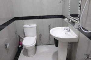 a bathroom with a white toilet and a sink at Sahasna Holiday Home in Diyatalawa