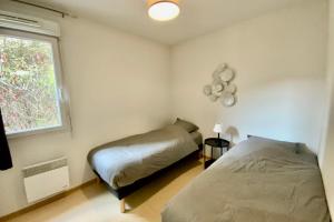 ein Schlafzimmer mit zwei Betten und einem Fenster in der Unterkunft Les Naïades H38 - 2 bedrooms for 6 people ! in Avène + 10 Fotos