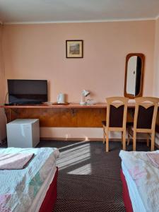 a hotel room with two beds and a television at Karet Obiekt Hotelowy in Skoczów