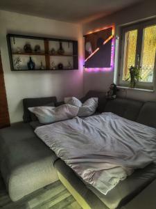 a bed in a bedroom with purple lights on the wall at Bungalow Donaublick mit Pool und Garten in Sankt Nikola an der Donau