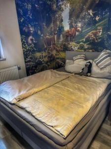 un letto in una stanza con un dipinto sul muro di Bungalow Donaublick mit Pool und Garten a Sankt Nikola an der Donau