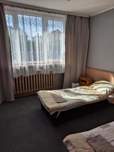 sypialnia z dwoma łóżkami i dużym oknem w obiekcie Karet Obiekt Hotelowy w mieście Skoczów