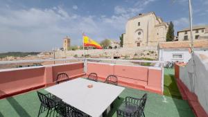een tafel en stoelen op een balkon met een vlag bij APCH V7 Torreón in Chinchón