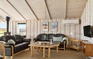 uma sala de estar com sofás de couro e uma mesa em Nice Home In Nordborg With Sauna em Nordborg