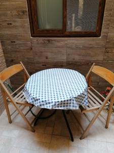 une table et deux chaises assises à côté d'un mur dans l'établissement Old refurbished Apartment in Bormla, à Cospicua