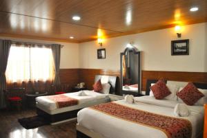 a hotel room with two beds in a room at Goroomgo Kasturi Palace Darjeeling - Luxury Room with Parking Facilities - Best Seller in Darjeeling