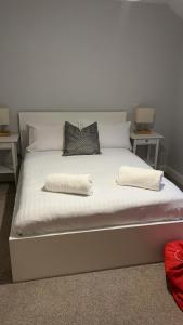 a white bed with two pillows on top of it at Oban Lorne Apartment in Oban +14 photos