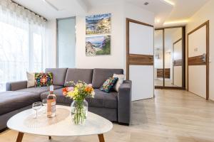 a living room with a couch and a table at Apartamenty & Spa Stara Polana in Zakopane