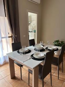 uma mesa de jantar com cadeiras e uma toalha de mesa branca sidx sidx sidx sidx em Collina Fleming 32 em Roma