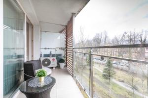 an apartment balcony with a table and a view at Apartamenty & Spa Stara Polana in Zakopane