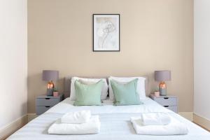 a bedroom with a white bed with two night stands at The Haggerston Collection in London