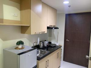 a small kitchen with a sink and a refrigerator at Brenthill Condo (Ceramic Unit) in Baguio