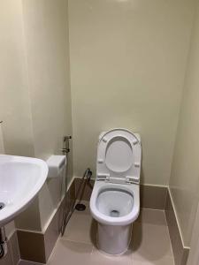 a bathroom with a toilet and a sink at Brenthill Condo (Ceramic Unit) in Baguio