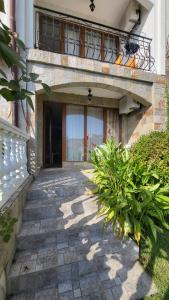 a stone walkway leading to a building with a balcony at Студио Костови Имоти in Sveti Vlas