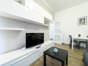 sala de estar con TV en una pared blanca en Realkasa Creti Apartment, en Bolonia