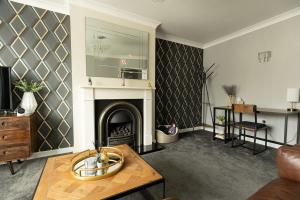 a living room with a fireplace and a table at WOODFIELD ROAD - Two bed in Harrogate with cosy living room fire. in Harrogate