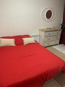 1 dormitorio con cama roja y espejo en Appartement vu sur la mer, en Port Leucate