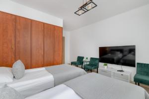 - une chambre avec 2 lits et une télévision à écran plat dans l'établissement Comfortable Apartment with Balcony in Krakow by Rent like home, à Cracovie