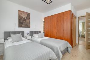 - une chambre avec 2 lits et un mur en bois dans l'établissement Comfortable Apartment with Balcony in Krakow by Rent like home, à Cracovie
