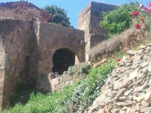 un bâtiment en pierre avec un tunnel sur une montagne dans l'établissement Apartamentos La Dama Azul, à Ágreda