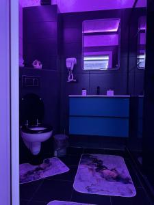 a purple bathroom with a toilet and a sink at Relax Regim Apartament in Bucharest