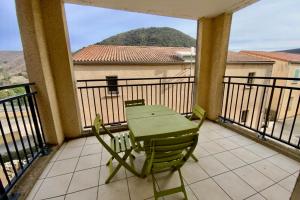 a green table and chair on a balcony with a view at Les Naïades I51- 2 bedrooms for 5 people ! in Avène +6 photos