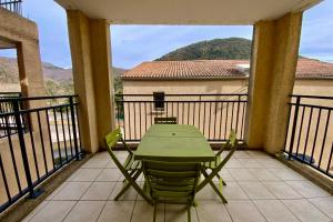 a green table and chairs on a balcony at Les Naïades I51- 2 bedrooms for 5 people ! in Avène