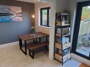 a dining room with a table and a shelf at Newly renovated 2-bed bungalow in Bath