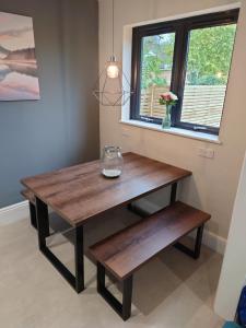 a wooden table and bench in a room with a window at Newly renovated 2-bed bungalow in Bath +7 photos