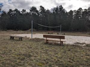 dos bancos y una red de voleibol en un campo en Holz-Hannes, en Mittenwalde