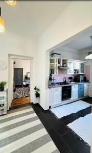 cocina con armarios blancos y suelo negro en Apartman Classy Pécs, en Pécs