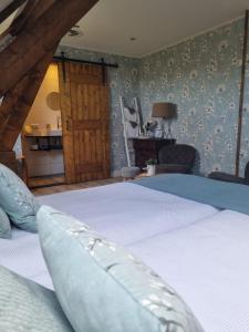 1 dormitorio con 1 cama grande y paredes azules en Bed & Breakfast aan de Beek, en Arcen