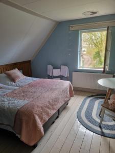 a bedroom with a bed and a large window at Bed & Breakfast aan de Beek in Arcen