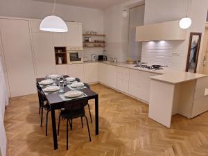 a kitchen with a black table and chairs in a room at Apartmán Sarlot (13) in Bratislava