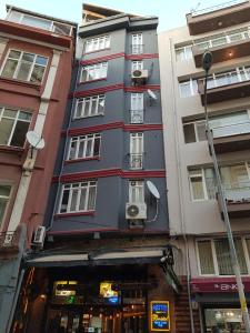 un grand bâtiment gris avec des fenêtres donnant sur une rue de la ville dans l'établissement KADIKÖY BRISTOL HOTEL, à Istanbul
