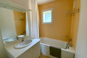 a bathroom with a sink and a tub and a mirror at Les Naïades I53 - 2 bedrooms for 5 people ! in Avène