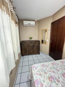 um quarto com uma cama, uma cómoda e uma janela em RJ Residencial Nosso Sonho com Piscina a 120m mar em Palhoça