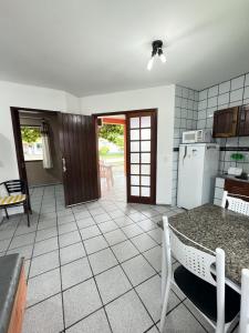 uma cozinha com uma mesa e um frigorífico em RJ Residencial Nosso Sonho com Piscina a 120m mar em Palhoça