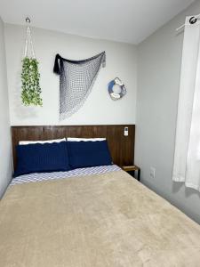 um quarto com uma cama com almofadas azuis em RJ Residencial Nosso Sonho com Piscina a 120m mar em Palhoça