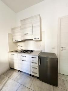 パルマにあるPalazzo Eliosの白いキャビネット、シンク、食器洗い機付きのキッチンが備わります。
