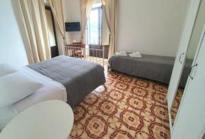 a hotel room with two beds and a window at Il MOLO Camere per vacanze in Diamante