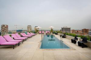 a row of pink chairs and a pool on a roof at Hotel Pinar Plaza in Madrid